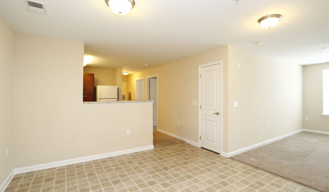 A room with a tile floor and a door on the right side at Granite Falls Apartments, Rolesville