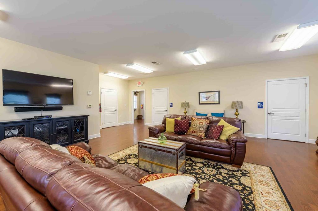 A living room with brown leather couches and a black entertainment center.