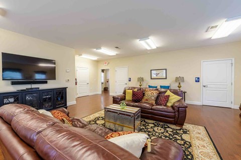 A living room with brown leather couches and a black entertainment center.
