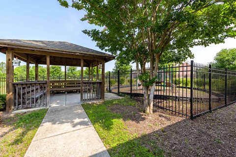 A gazebo is surrounded by a black fence and a tree at Granite Falls Apartments, Rolesville, NC