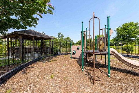 A playground with a slide, swings, and a gazebo at Granite Falls Apartments, Rolesville, NC, 27571