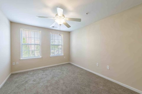 A room with a ceiling fan and two windows at Granite Falls Apartments, Rolesville, North Carolina