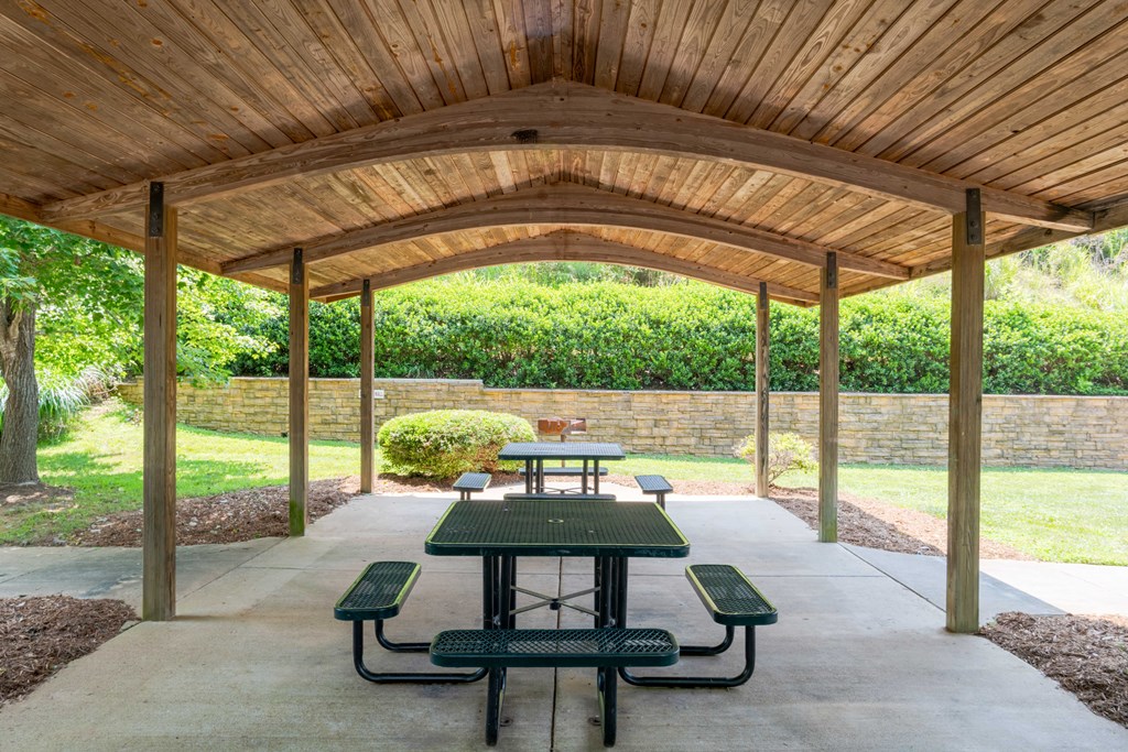 Picnic tables under a wooden pavilion.