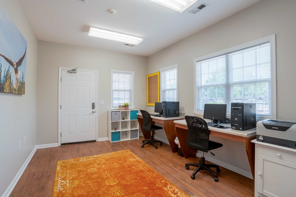 A room with a white door, a yellow door, and a desk with a computer and printer.