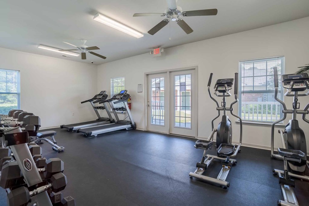 A spacious gym with treadmills, stationary bikes, and dumbbells.at Hartsville Garden Apartments, Hartsville, SC