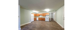 A kitchen with wooden cabinets and white appliances.at Kinston Hotel Apartments, Kinston North Carolina