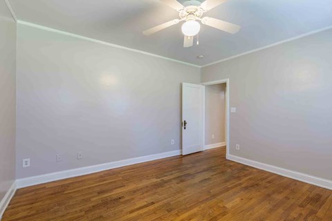 A room with a ceiling fan and wooden floors.at Kinston Oaks Apartments, Kinston, NC 28501