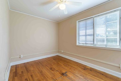 A room with a ceiling fan and a window with blinds.at Kinston Oaks Apartments, Kinston, NC