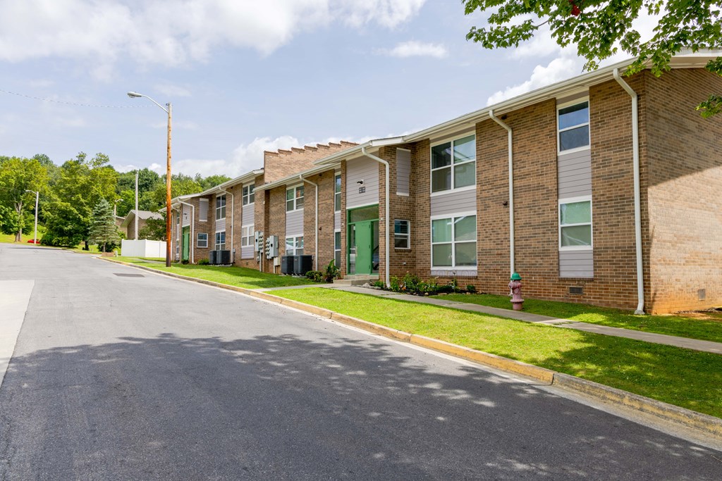 A street view of a residential area with apartment buildings on the right.