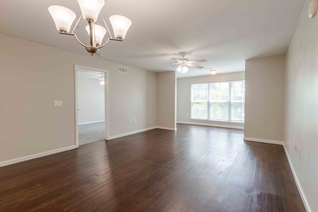 A room with wooden floors and a chandelier.at Marsh View Place, Charleston