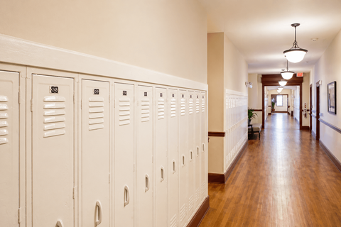A long hallway with white lockers on the side.