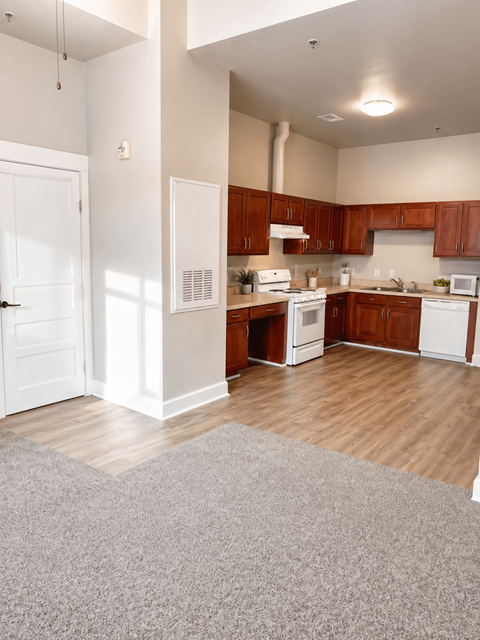 A kitchen with white appliances and wooden cabinets.