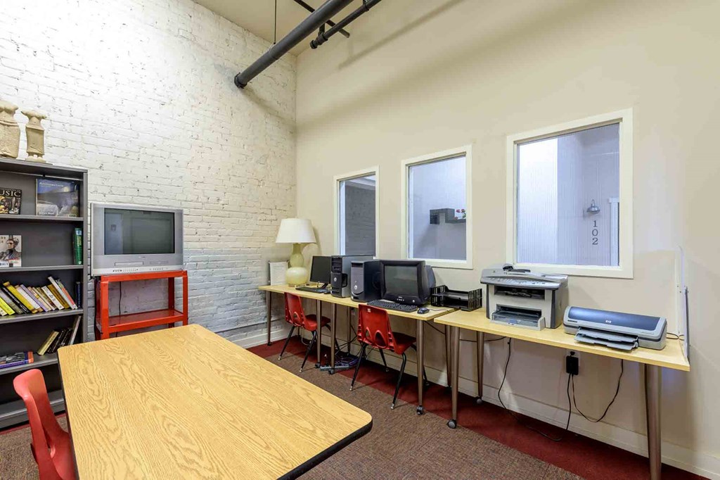 A room with a desk, chairs, and computers at Nantucket Lofts Apartments, Kinston