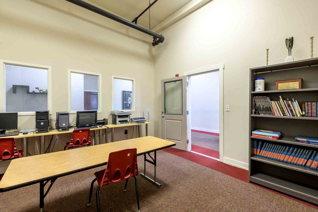 A room with a table, chairs, and a bookshelf at Nantucket Lofts Apartments, Kinston, NC
