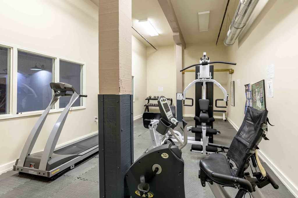 A gym with treadmills, weights, and exercise machines at Nantucket Lofts Apartments, Kinston, NC