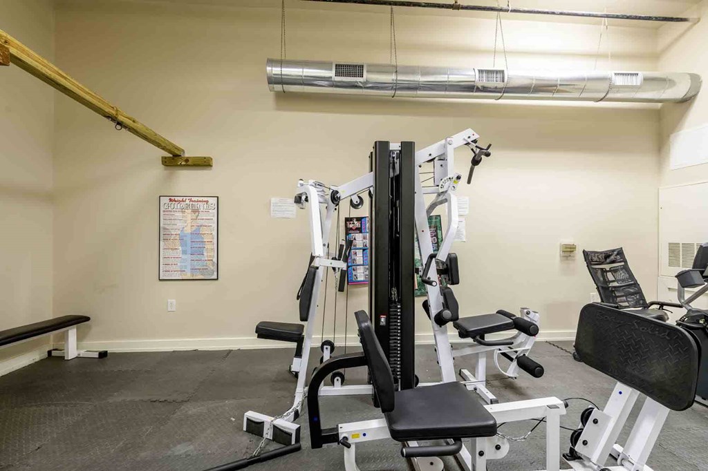 A gym with a variety of equipment including a leg press machine at Nantucket Lofts Apartments, Kinston, NC