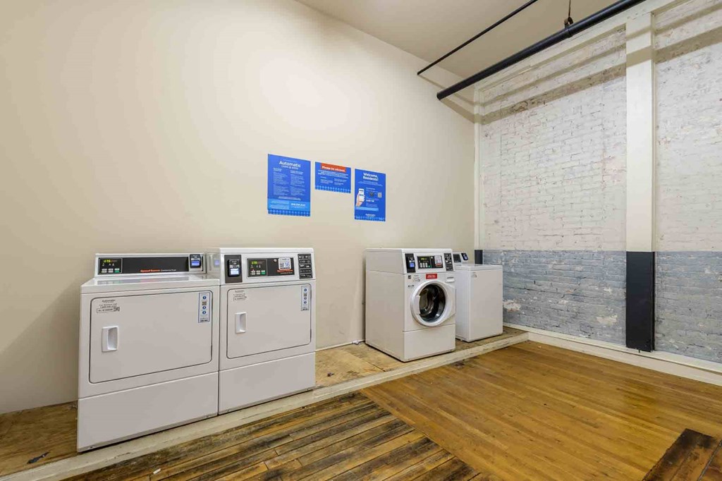 A room with two washing machines and a dryer at Nantucket Lofts Apartments, Kinston, NC