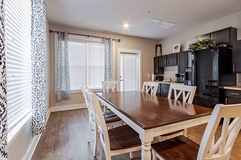 A dining room with a wooden table and chairs.