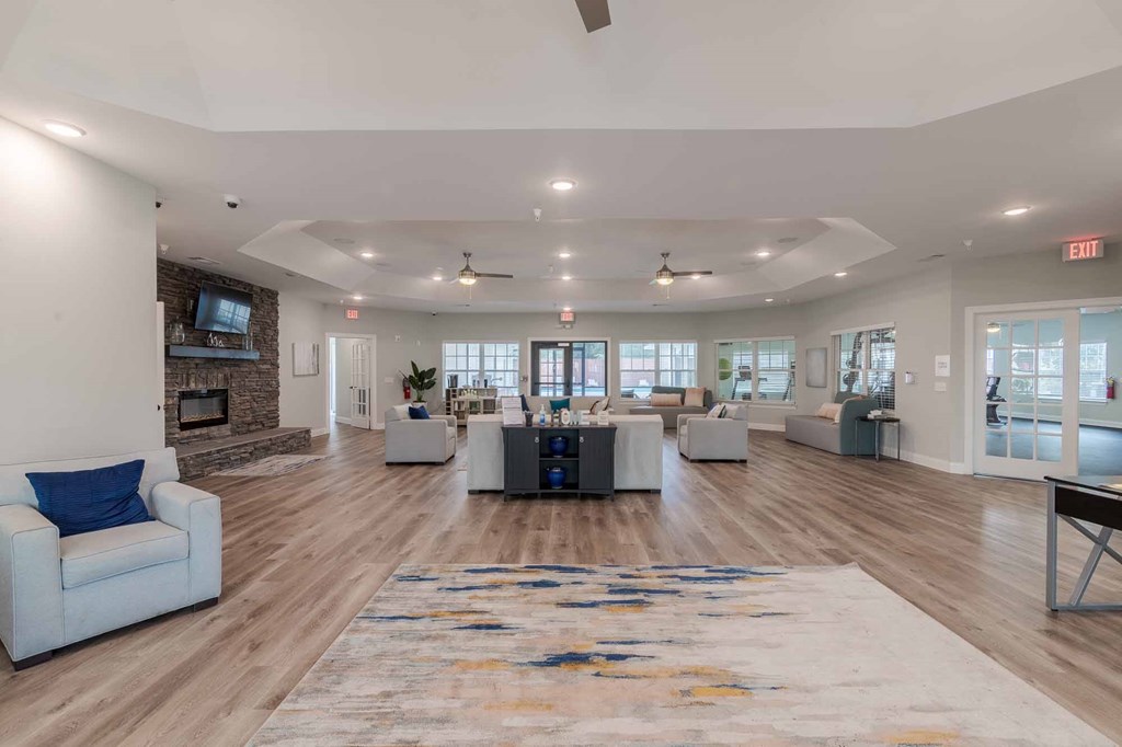A spacious living room with a fireplace and a large rug on the floor.