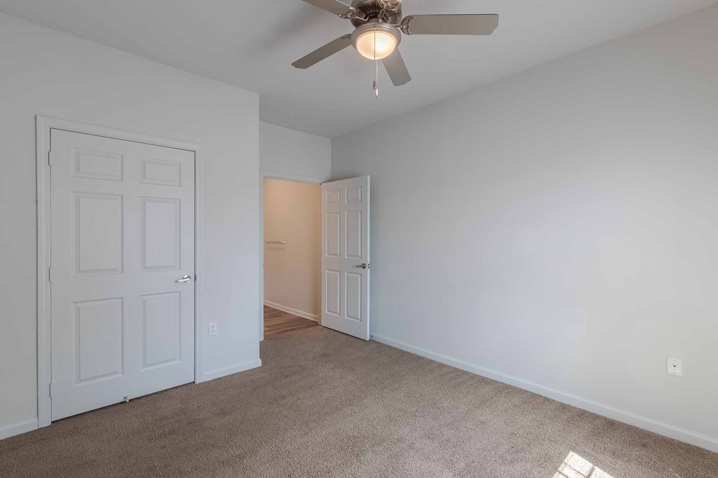 A room with a ceiling fan and two doors.