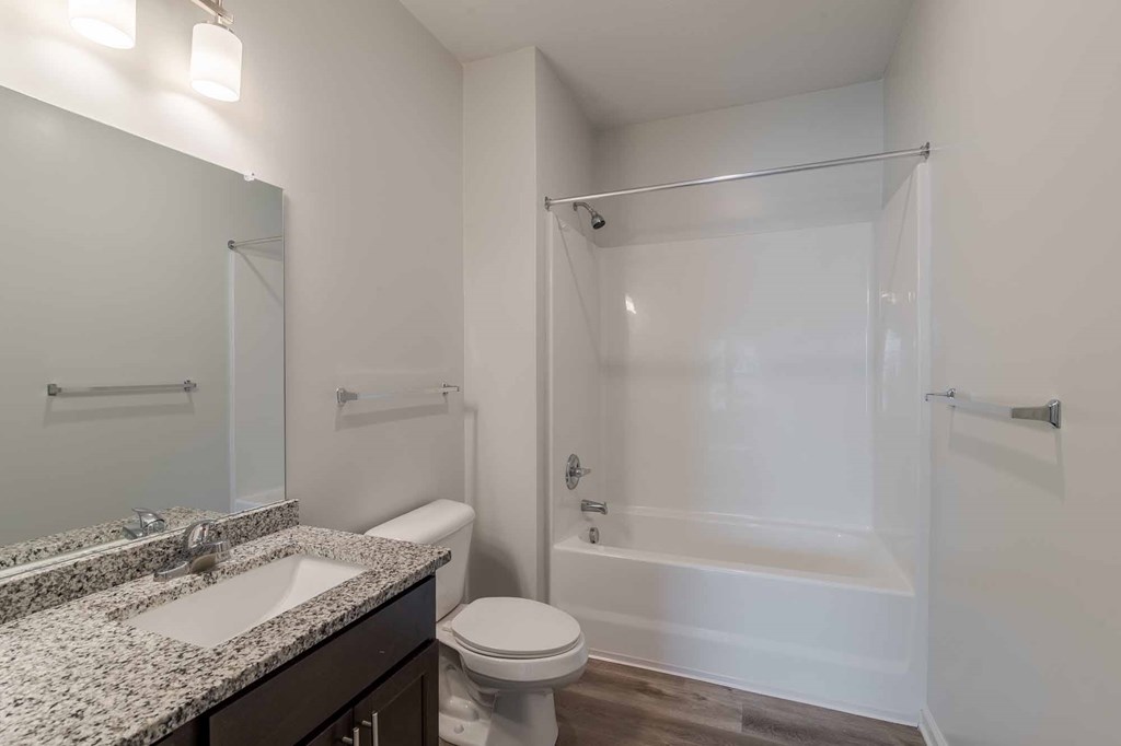 A bathroom with a toilet, sink, and shower.