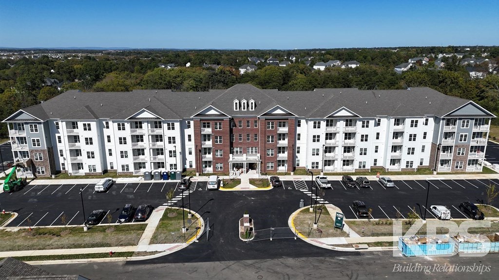 an aerial view of an apartment building and parking lot
