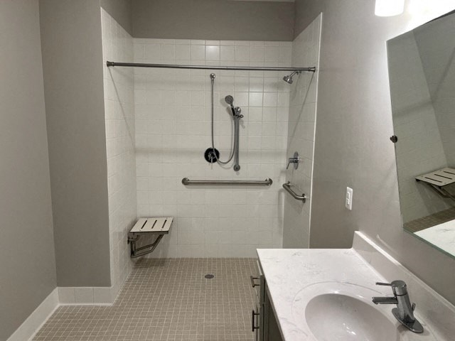 a bathroom with a shower and a sink and a mirror