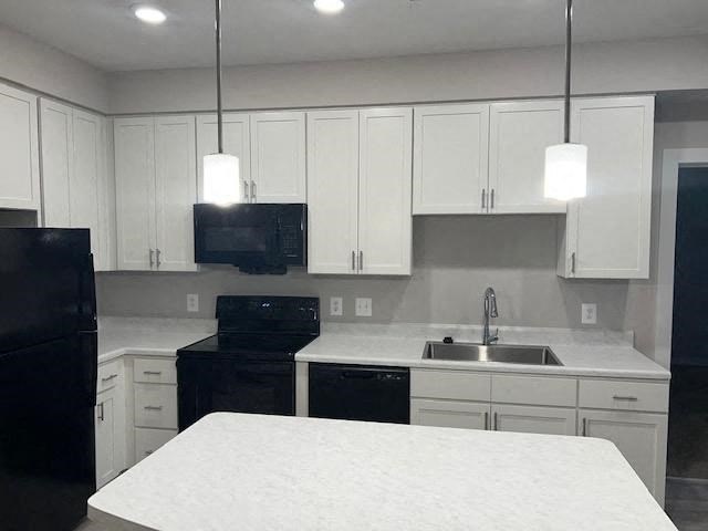 a white kitchen with black appliances and white cabinets