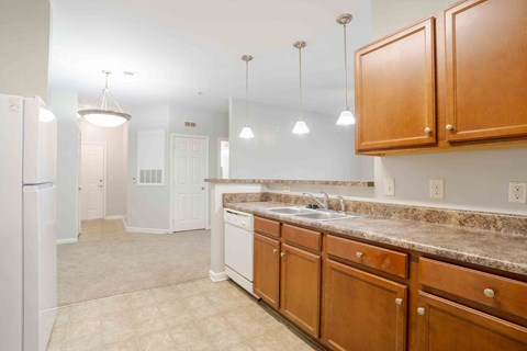 A kitchen with wooden cabinets and a granite countertop.