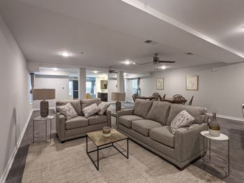 A living room with a grey couch and a glass coffee table. at Bickerstaff Crossing Apartments, Henrico, VA