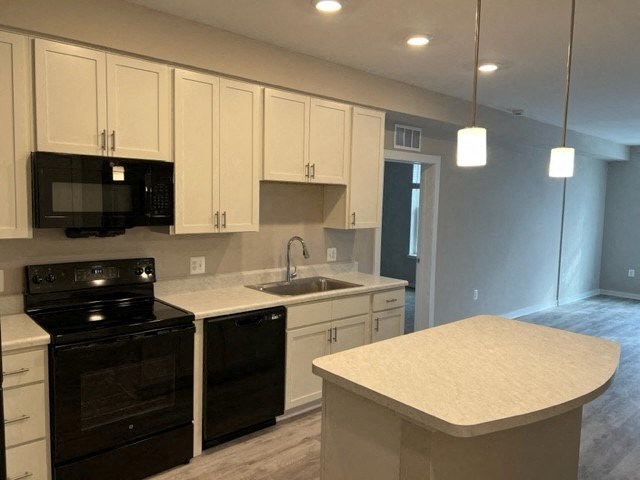 a kitchen with black appliances and white cabinets