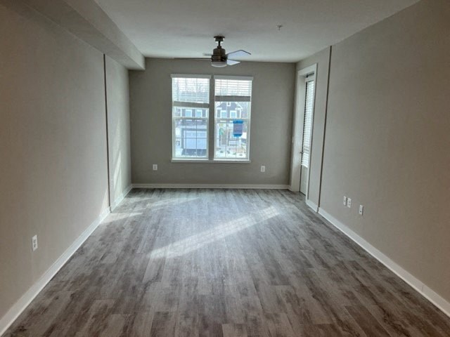 an empty living room with wood floors and a window