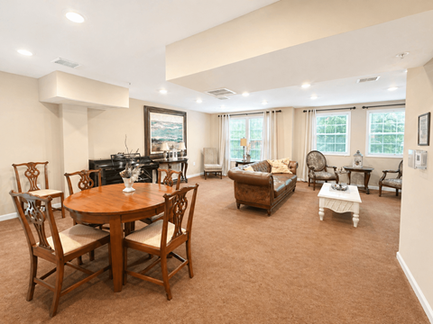 A living room with a brown carpet and wooden furniture.