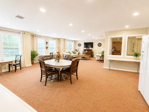 A dining room with a table set for six people.
