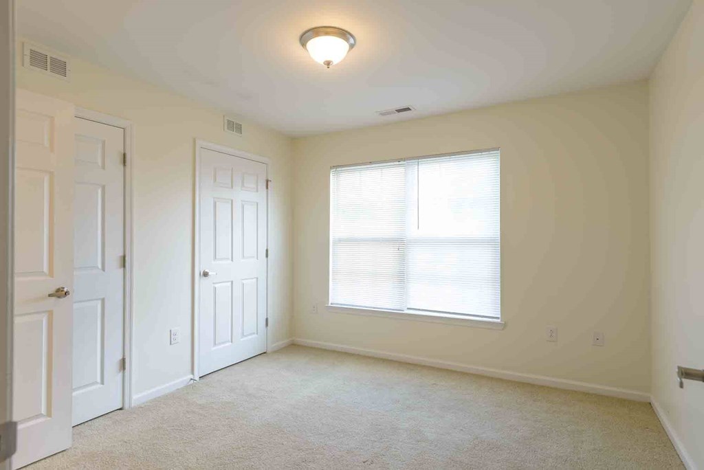 A room with a window and a carpeted floor at Robinson Park Apartments, Virginia, 22801