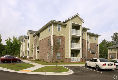 A large apartment building with a parking lot in front.at Summerville Garden, Summerville South Carolina