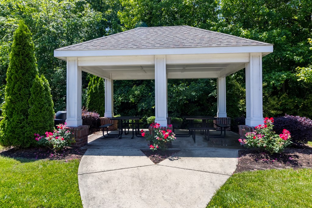 Resident Pavilion Surrounded by Lush Greenery Charming community pavilion surrounded by vibrant landscaping and mature trees, perfect for social gatherings at Snowden Senior Apartments.