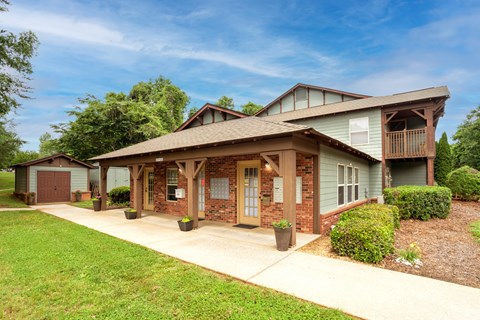 A house with a green lawn and a brown roof.