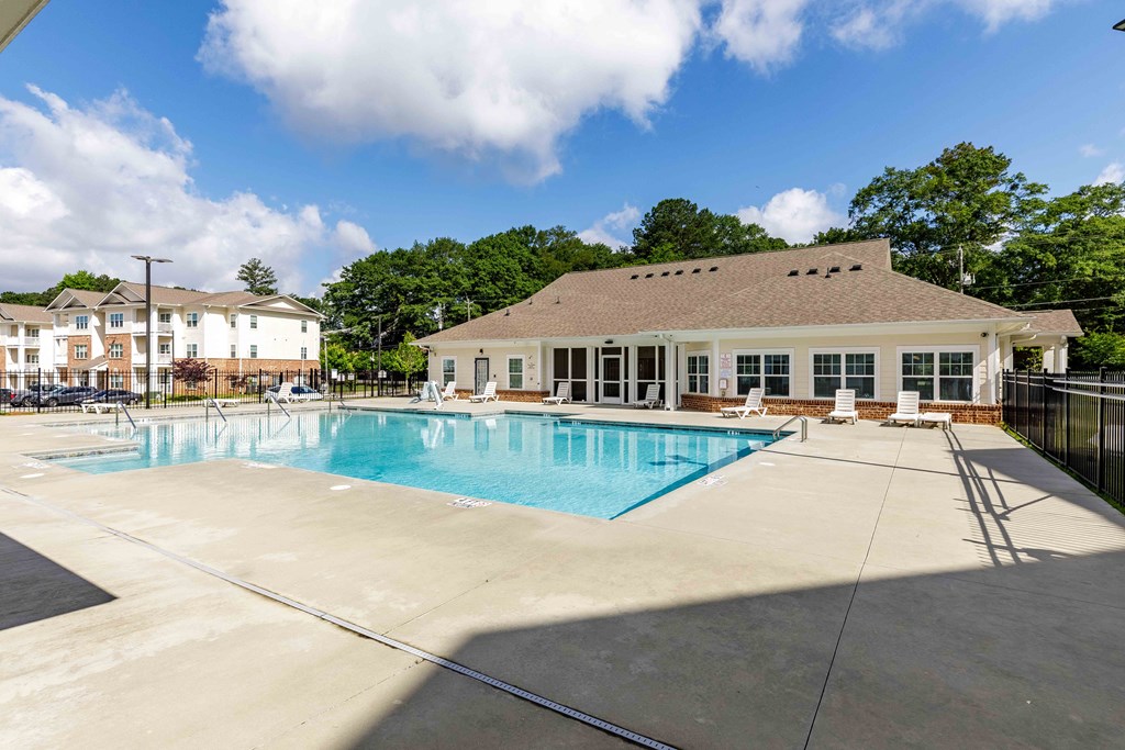 A large swimming pool with a building behind it.