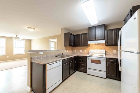 A kitchen with a white refrigerator, a white stove, and a white dishwasher.
