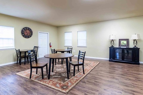 A dining room with a round table and chairs.