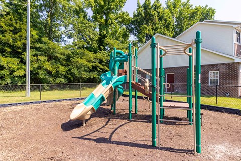 A playground with a green slide and a brown sandbox. at The Shire Apartments, Chesapeake, VA, 23325
