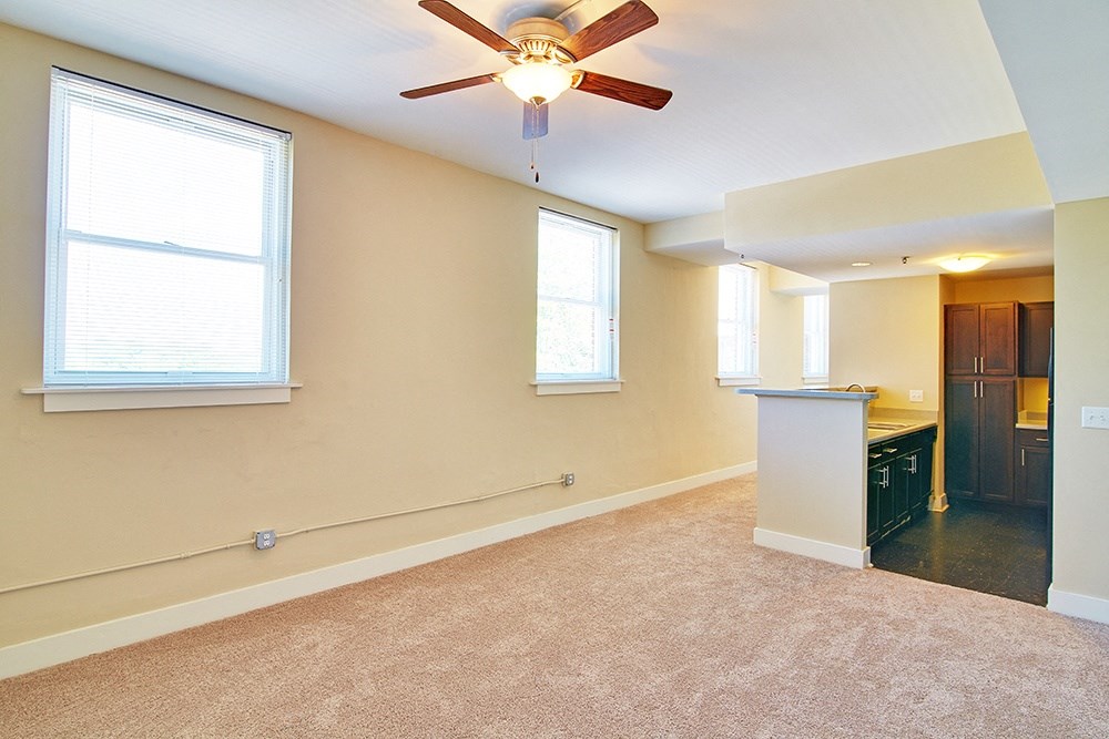 an empty kitchen and living room with a ceiling fan