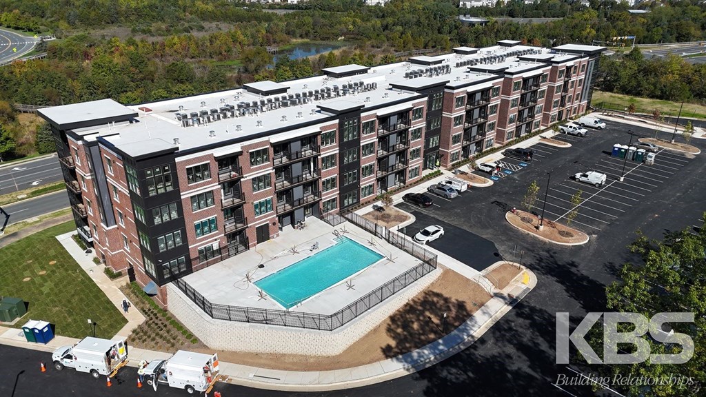 a rendering of an apartment building with a pool and parking lot