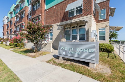 A sign that says West Yarde stands in front of a building.