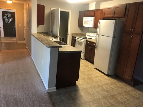 a kitchen with white appliances and brown cabinets