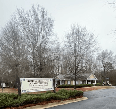 A sign for Berea Heights Apartments is in front of a building.