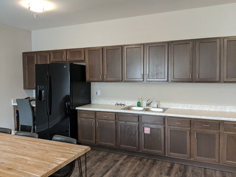 a kitchen with wooden cabinets and a black refrigerator