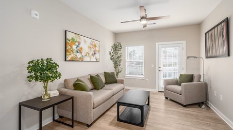 A living room with a couch, a coffee table, and a painting on the wall.