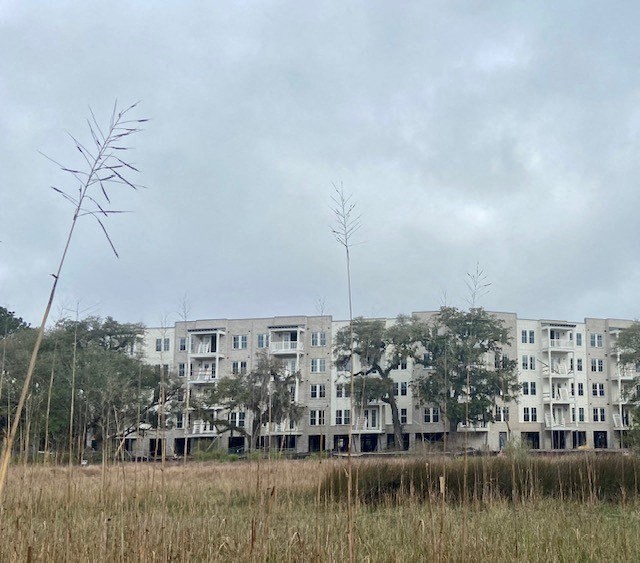 an apartment building in front of a field of grass